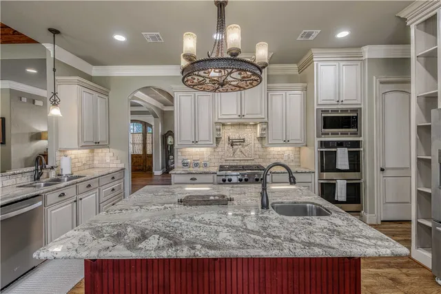 a kitchen with stainless steel appliances granite countertop a sink refrigerator and cabinets