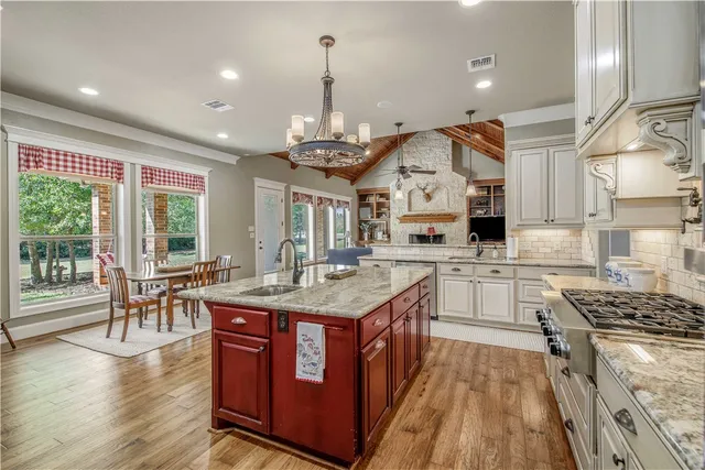 a kitchen with stainless steel appliances granite countertop a sink stove and refrigerator