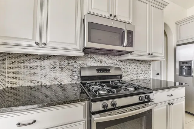 a stove top oven sitting inside of a kitchen