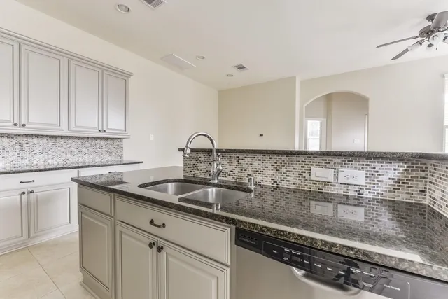 a kitchen with granite countertop a sink and cabinets