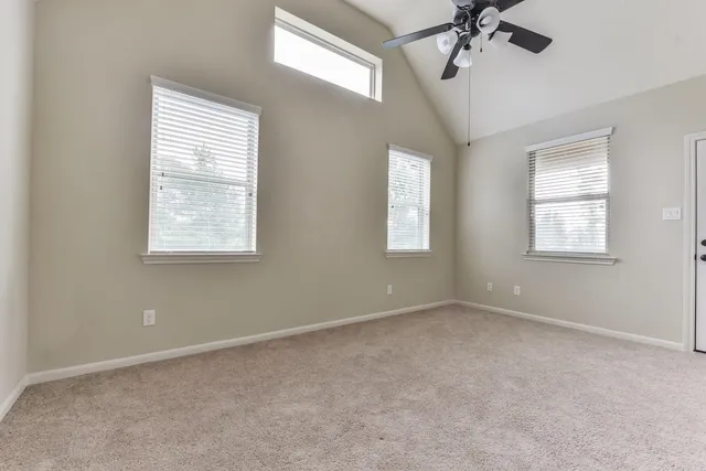 an empty room with windows and fan