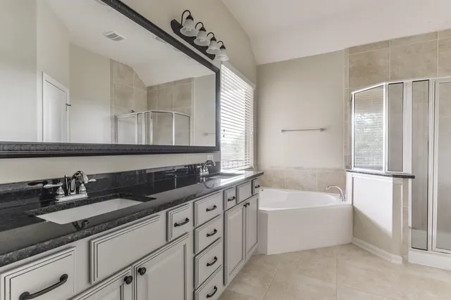 a bathroom with a tub sink and mirror