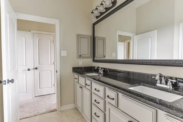 a bathroom with a granite countertop sink and a mirror