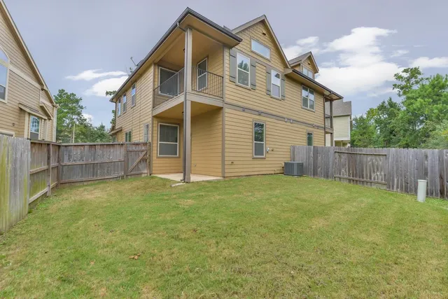 a view of a house with backyard and wooden fence