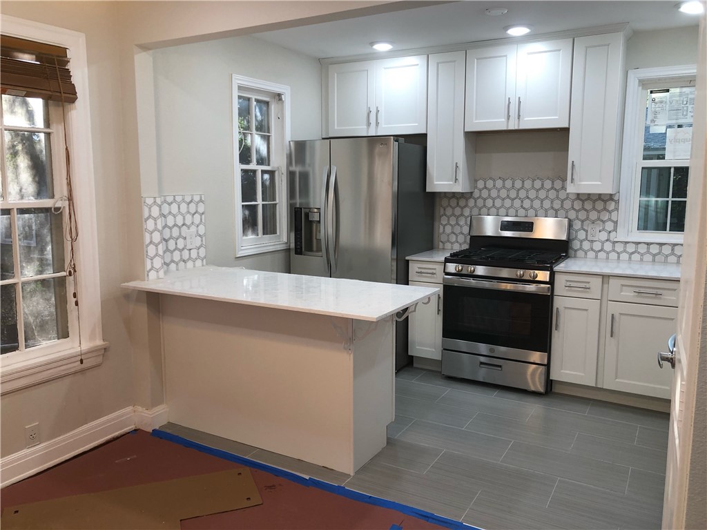 a kitchen with a stove a refrigerator and a sink