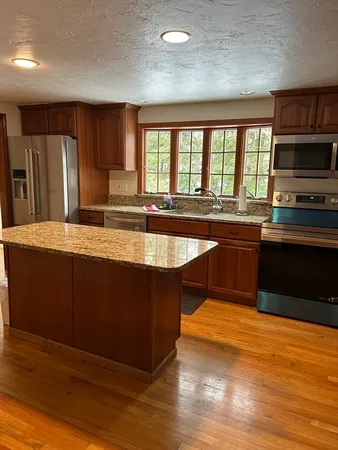 a large kitchen with wooden cabinets and a sink