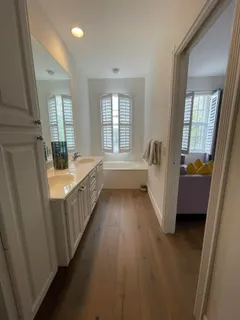 a view of a bedroom with wooden floor and balcony
