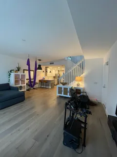 a living room with furniture and a gym equipment