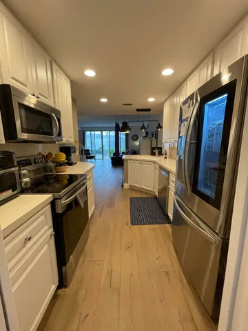 a kitchen with stainless steel appliances granite countertop wooden cabinets a stove top oven a sink and dishwasher