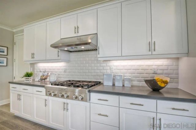 a kitchen with stainless steel appliances granite countertop a sink a stove and cabinets