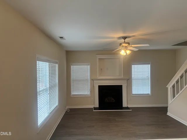 a view of an empty room with window and fireplace