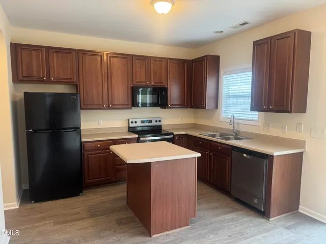 a kitchen with stainless steel appliances granite countertop a refrigerator stove a sink and dishwasher
