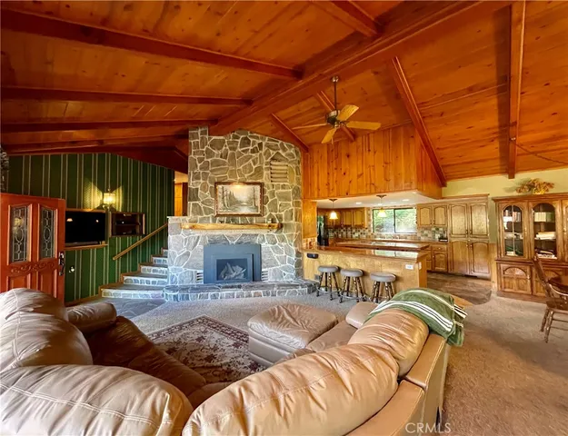 a living room with furniture a fireplace and a floor to ceiling window
