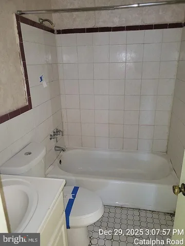 a bath tub sitting next to a white toilet and sink