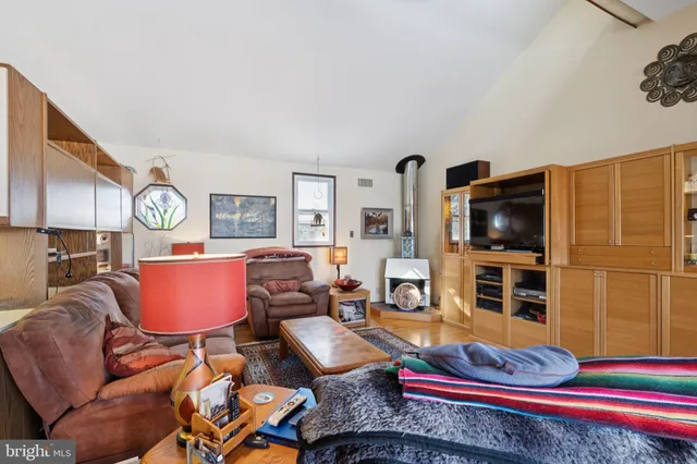 a living room with furniture a flat screen tv and kitchen view