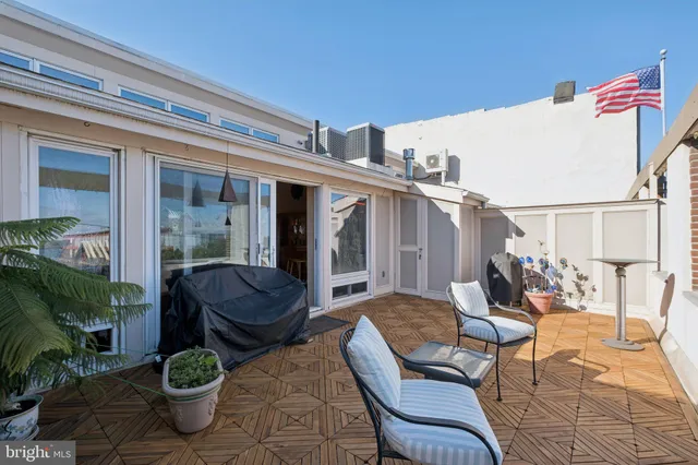 a view of a patio with couple of chairs and a potted plant