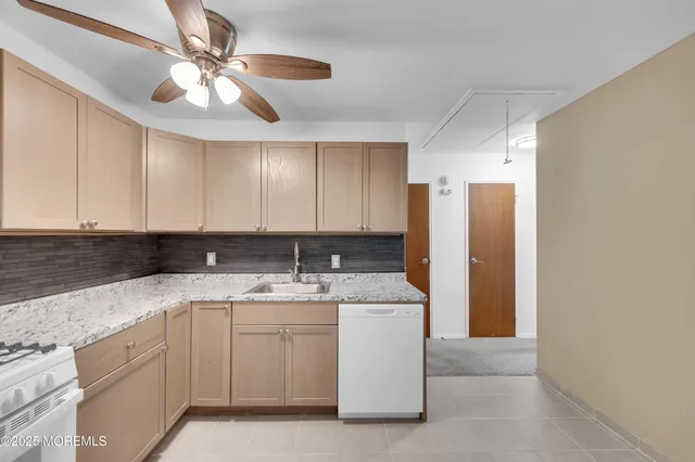 a kitchen with a sink a refrigerator and cabinets