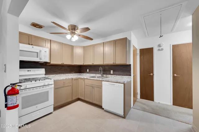 a kitchen with kitchen island white cabinets appliances and sink