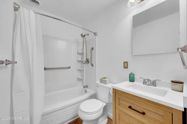 a bathroom with a granite countertop sink a toilet and shower
