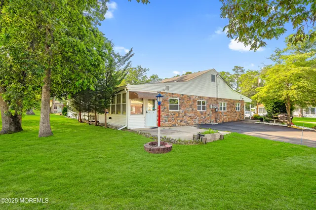 a view of a house with a yard and a tree
