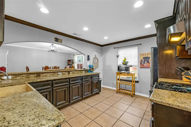 a large kitchen with stainless steel appliances granite countertop a sink and cabinets