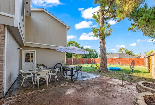 a backyard of a house with table and chairs