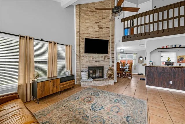 a living room with furniture a fireplace and a floor to ceiling window