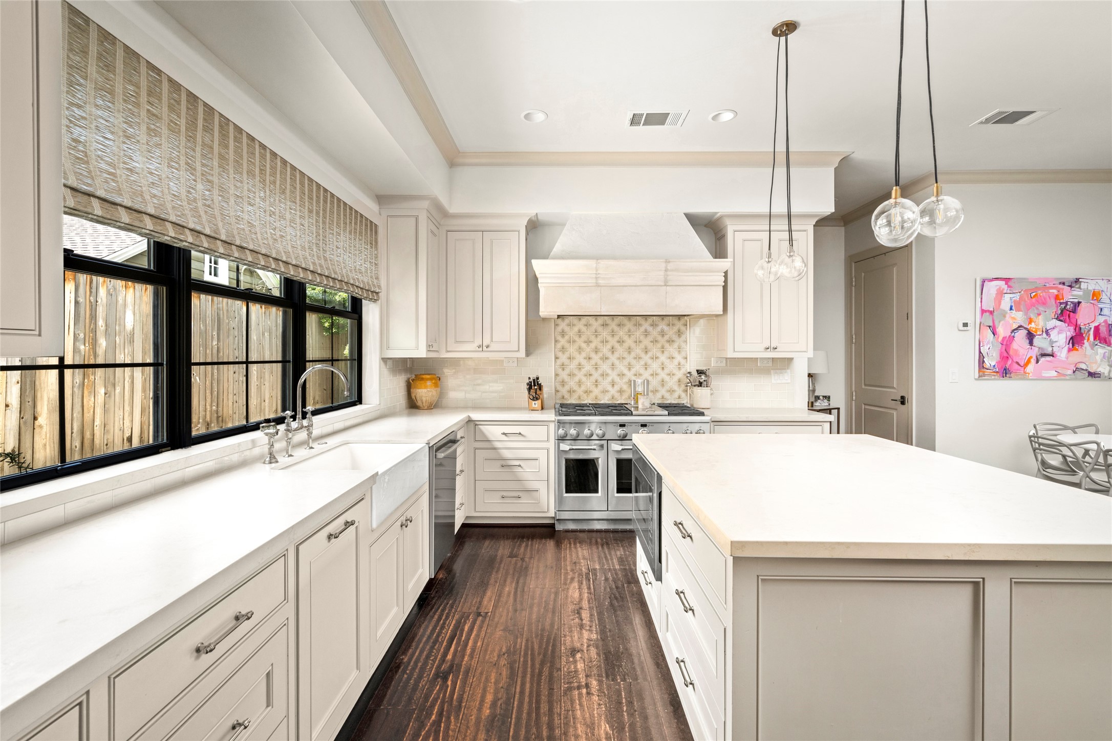 2216 Stanmore Drive Houston, TX 77019 - Photo 23 of 46 Custom cabinetry, a statement vent hood, designer tile detail, and polished Circa island pendants create a tailored kitchen that feels both elegant and highly functional.