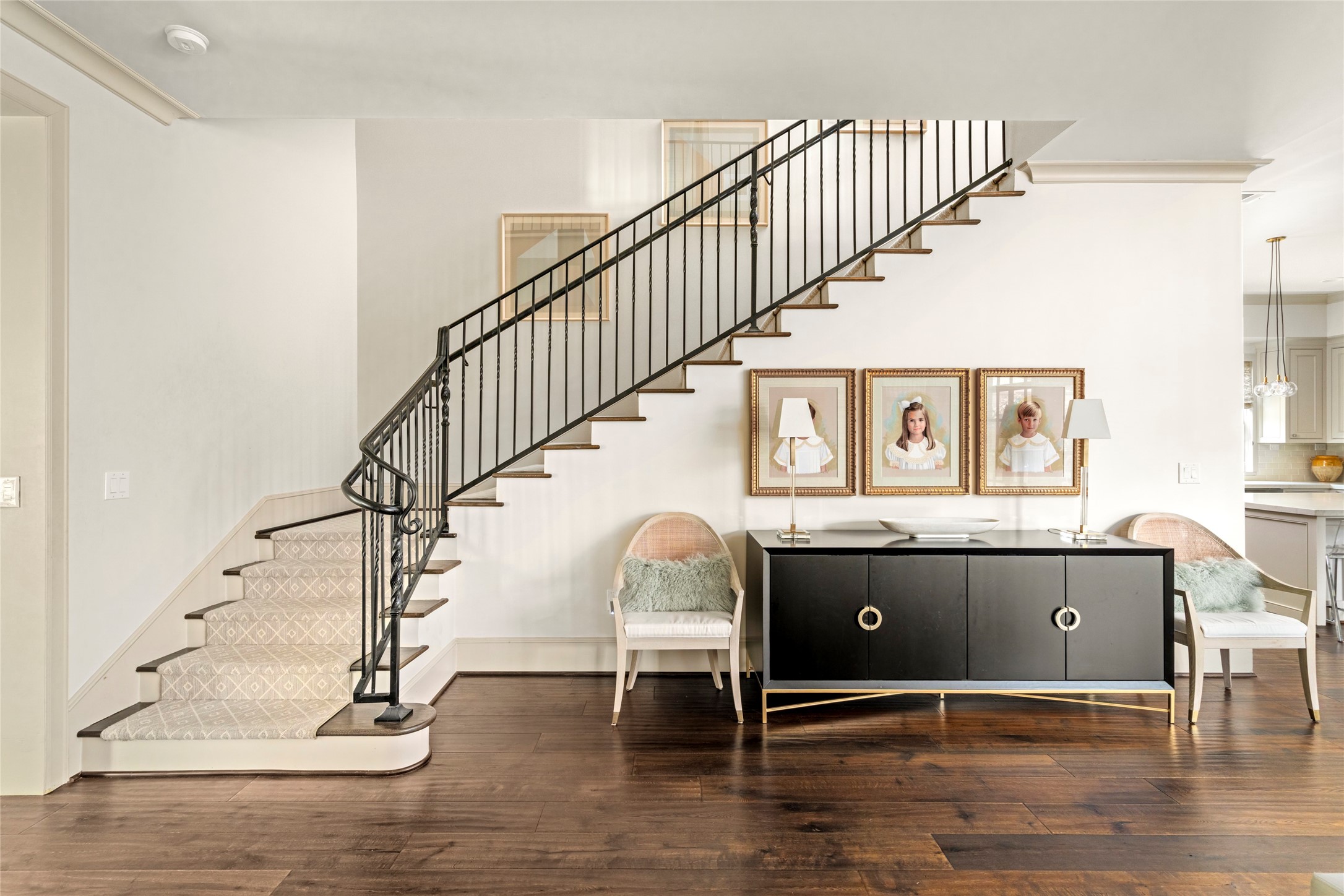 2216 Stanmore Drive Houston, TX 77019 - Photo 24 of 46 A graceful staircase with custom iron railing, patterned runner, and dark hardwood floors adds architectural character and a polished transition between the home’s main living spaces.