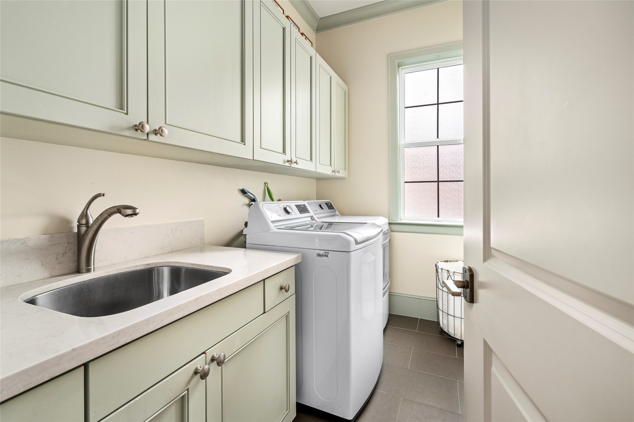 2216 Stanmore Drive Houston, TX 77019 - Photo 39 of 46 Convenient second-floor laundry room with built-in cabinetry, sink, counter space, and natural light, ideally positioned near the bedroom level.