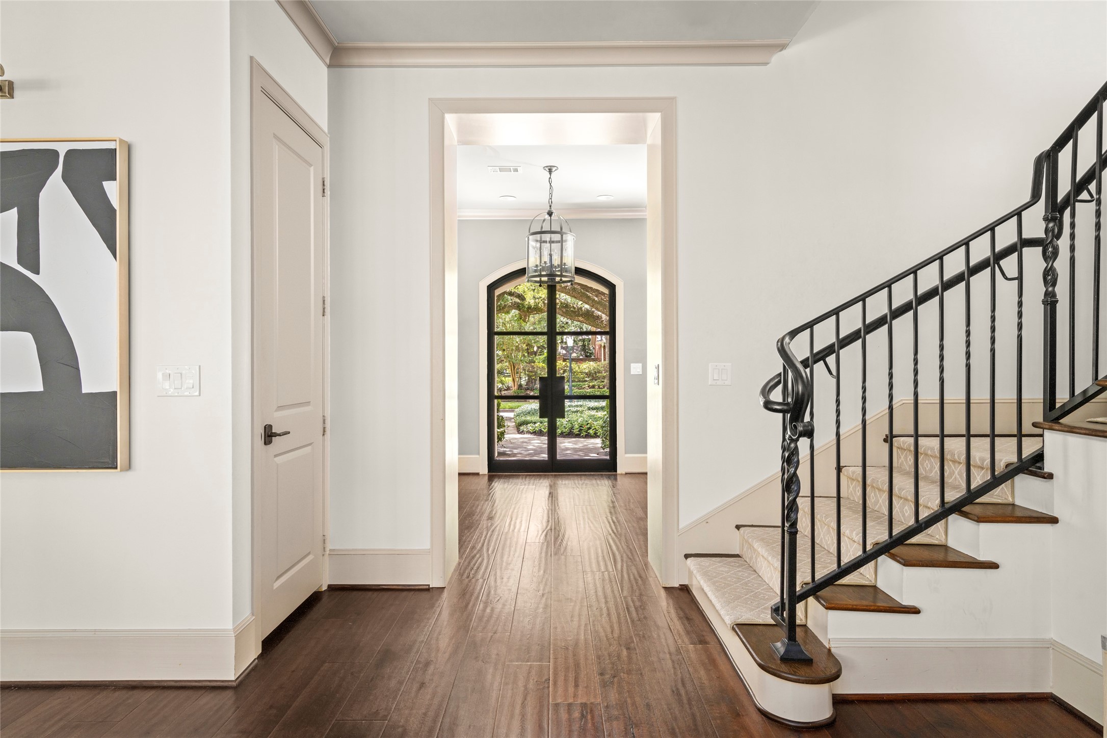 2216 Stanmore Drive Houston, TX 77019 - Photo 4 of 46 A graceful stair hall with hardwood floors, custom iron railing, and framed views to the front gardens creates a refined transition through the home.
