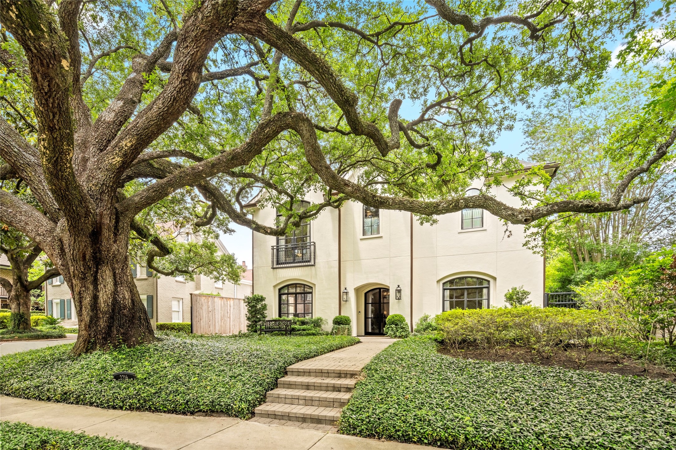 2216 Stanmore Drive Houston, TX 77019 - Photo 46 of 46 A sweeping live oak canopy and layered front landscaping create a beautiful sense of arrival, leading to the home’s arched entry and classic setting.