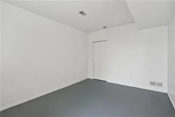 an empty room with wooden floor and white walls