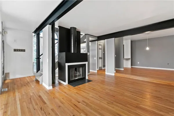 a view of a livingroom with wooden floor and a fireplace
