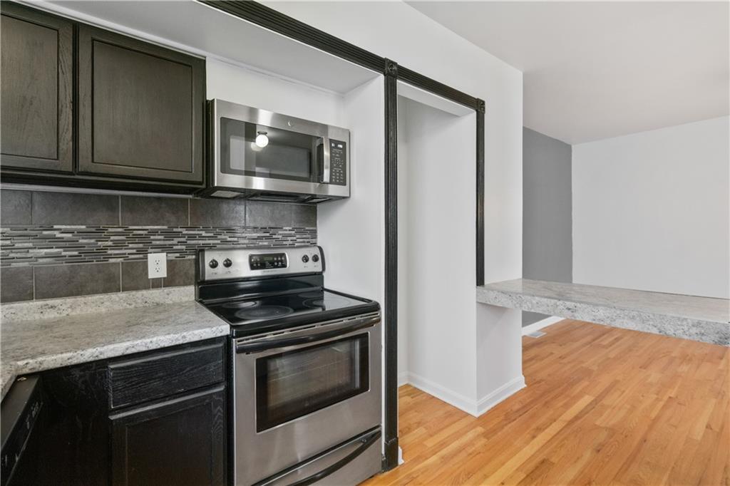 675 College Street, Unit A Pittsburgh, PA 15232 - Photo 9 of 28 a kitchen with stainless steel appliances granite countertop a stove microwave and sink