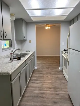 a kitchen with granite countertop a sink a counter top space and cabinets