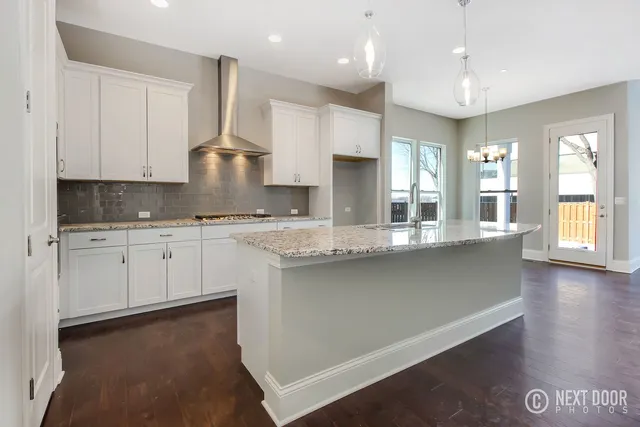 a large kitchen with stainless steel appliances kitchen island granite countertop a sink and cabinets