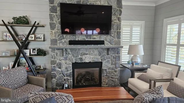 a living room with stainless steel appliances furniture a rug and a kitchen view