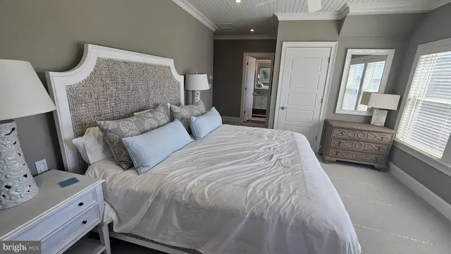 a bedroom with a bed next to a window and a flat screen tv