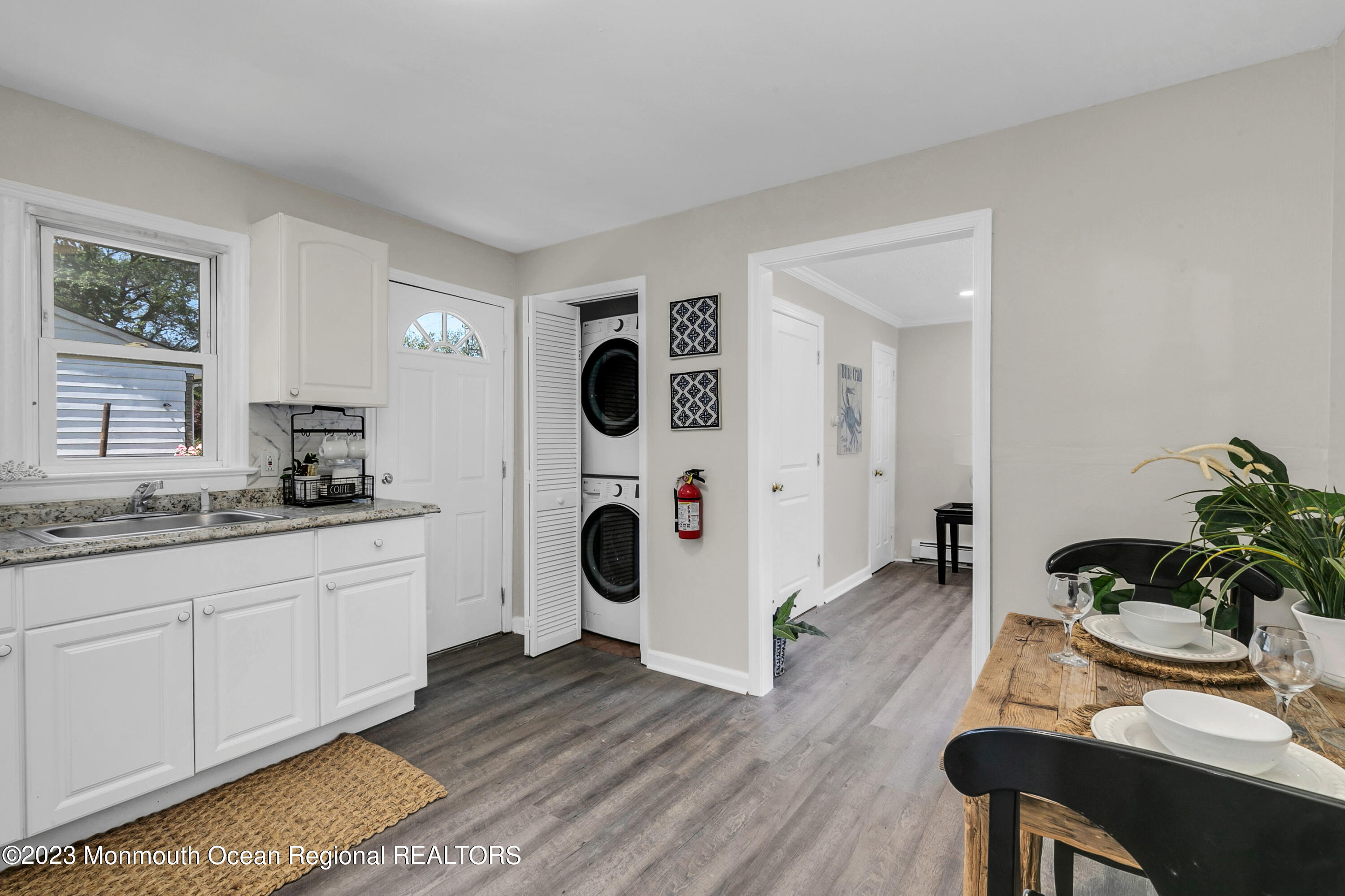 197 Raritan Street Keyport, NJ 07735 - Photo 21 of 28 a living room with kitchen island a wooden floor and white walls