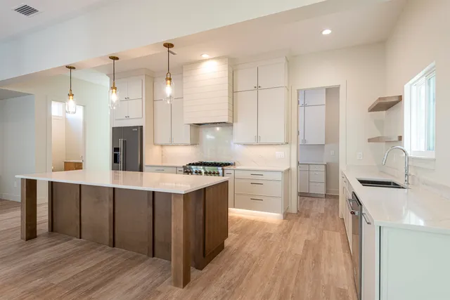 a kitchen with kitchen island a sink stainless steel appliances and cabinets