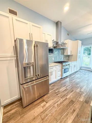 a kitchen with stainless steel appliances granite countertop a refrigerator and a stove