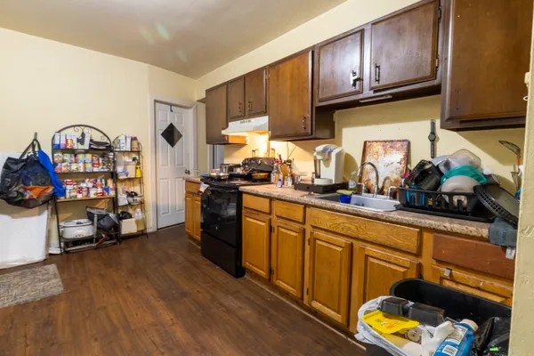 a kitchen with stainless steel appliances granite countertop a refrigerator a sink dishwasher and a stove with wooden floor