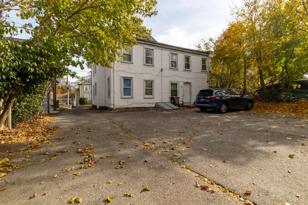 a view of house with car parked beside of road