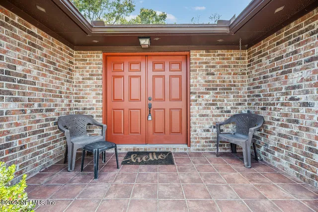a view of a door with chair and a potted plant