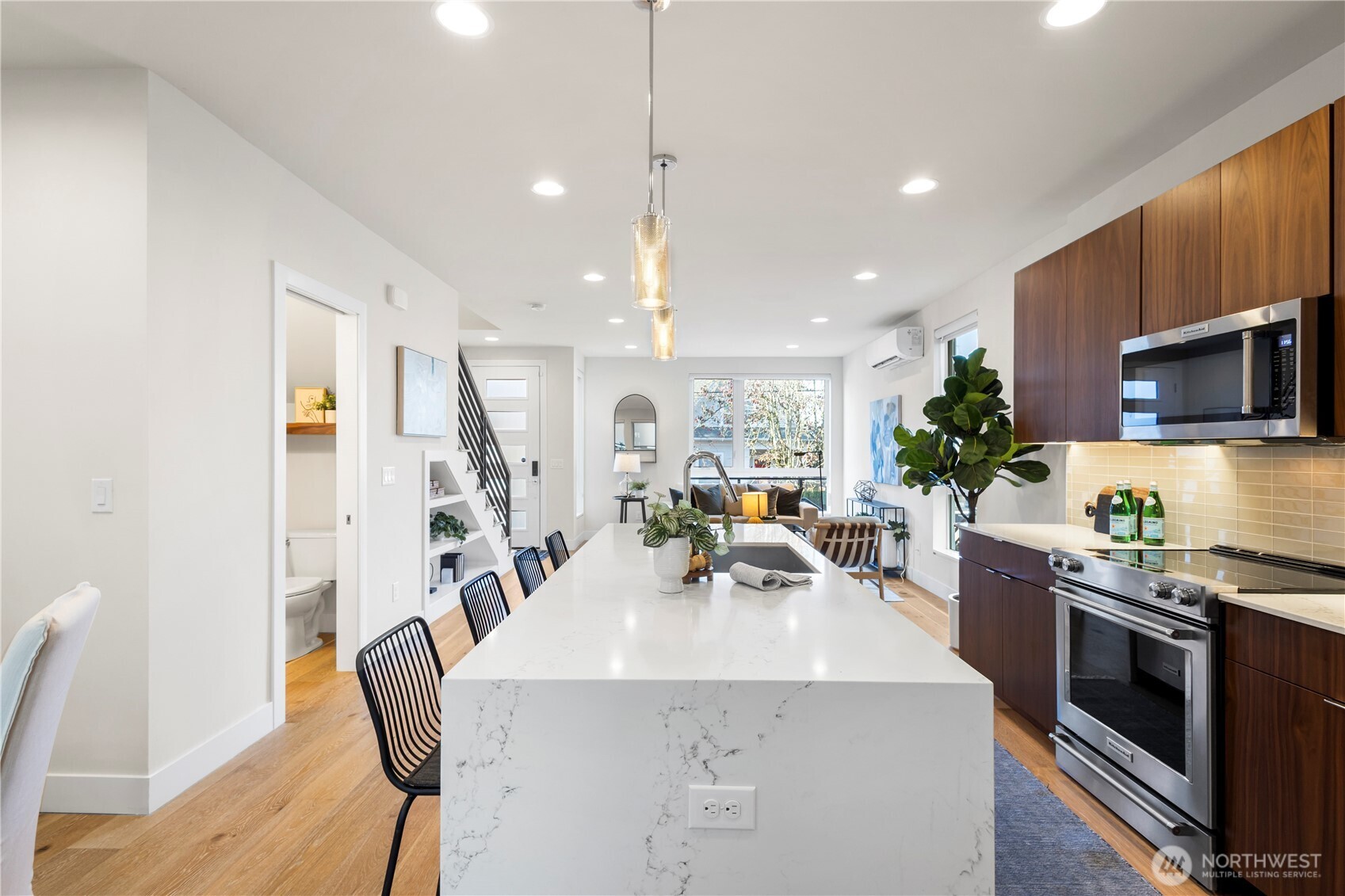 2212 Franklin Avenue East, Unit B Seattle, WA 98102 - Photo 6 of 32 a kitchen with stainless steel appliances a table chairs in it and wooden floors