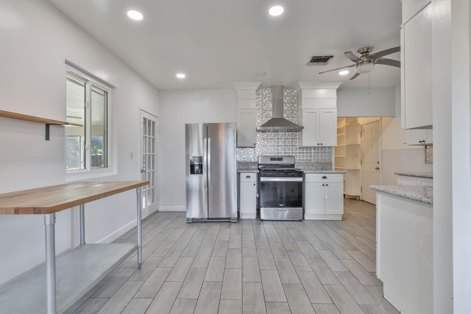 5856 East Park Cir Drive Fresno, CA 93727 - Photo 11 of 47 a large kitchen with stainless steel appliances a refrigerator and a stove top oven