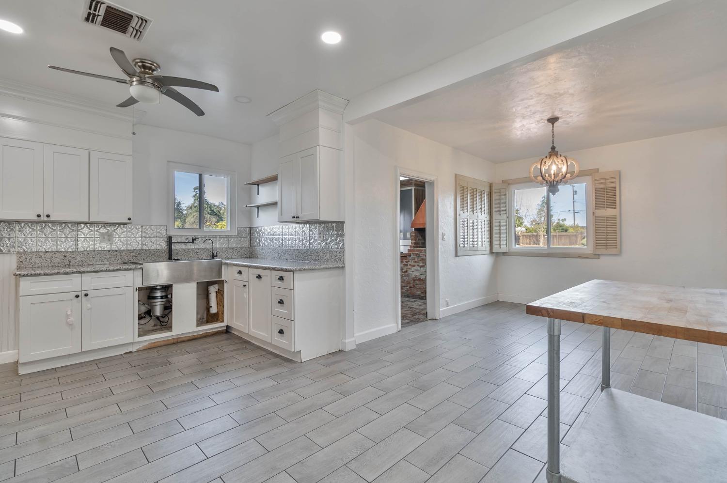 5856 East Park Cir Drive Fresno, CA 93727 - Photo 12 of 47 a kitchen with a stove a sink a window and cabinets