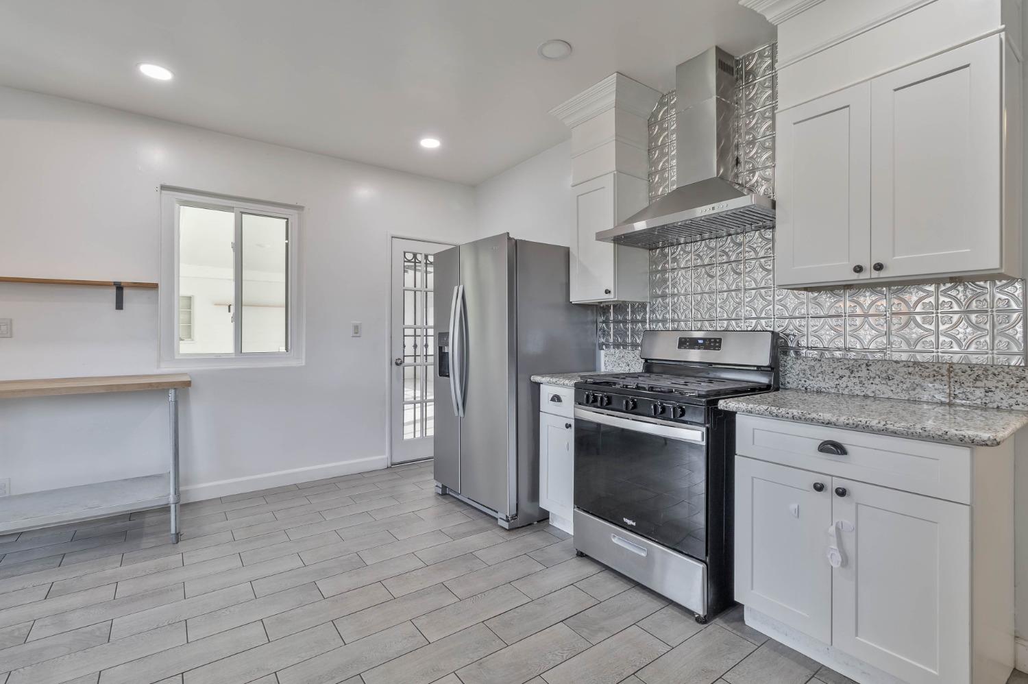 5856 East Park Cir Drive Fresno, CA 93727 - Photo 13 of 47 a kitchen with stainless steel appliances granite countertop a stove a refrigerator and a sink