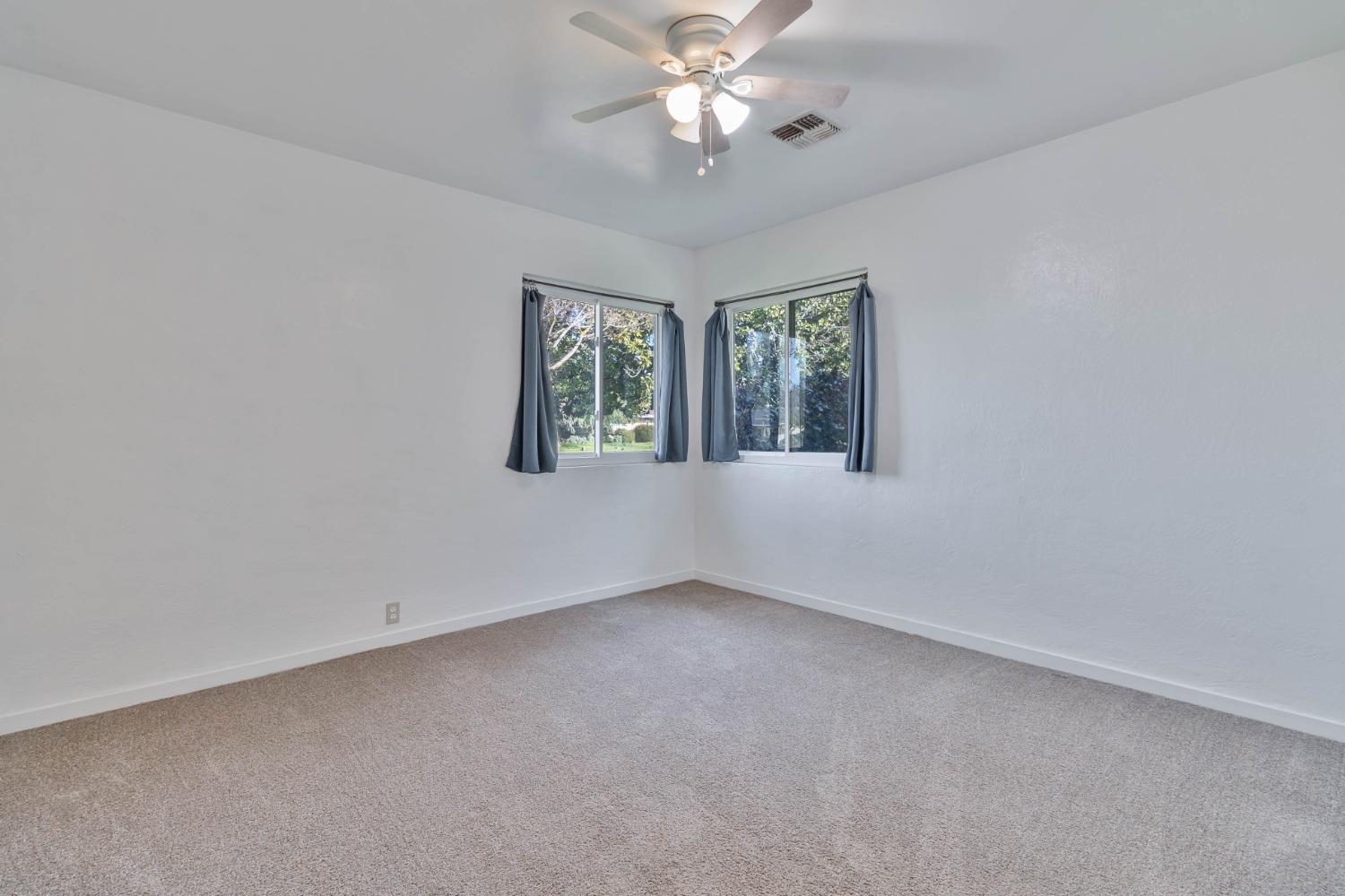 5856 East Park Cir Drive Fresno, CA 93727 - Photo 18 of 47 an empty room with windows and fan